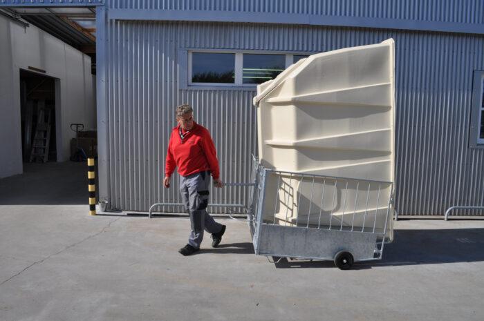 Transporte de la caseta para terneros inclinada hacia el FlexyFence con la ayuda de dos ruedas incorporadas al FlexyFence