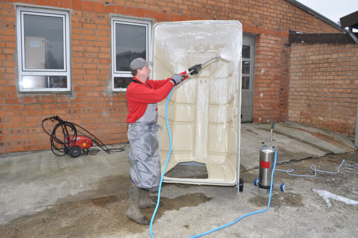 Reiniging van het omhooggeklapte Calf-Tel-kalverhok.