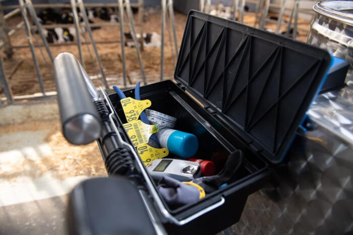 This detail photo shows an opened glove compartment on the MilkTaxi. It contains aids such as ear tags, a Brix refractometer and a calf measuring tape.